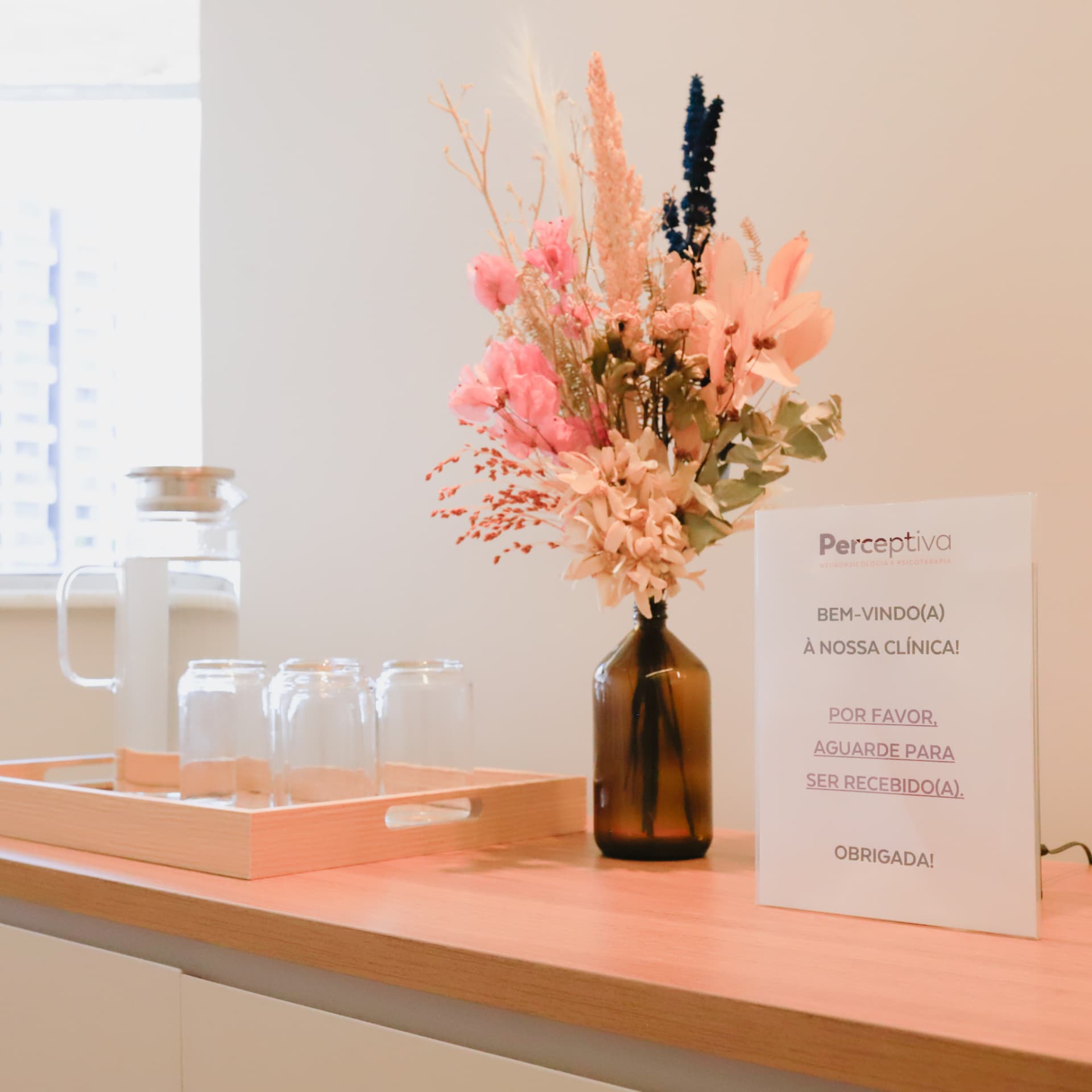 Recepção da Perceptiva com arranjo floral e água para os visitantes